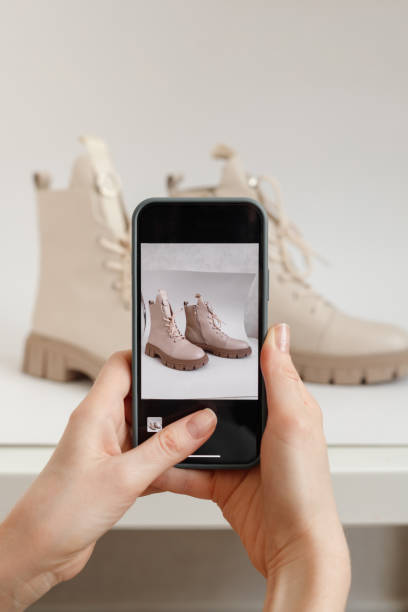 Woman takes a Picture of New or use Shoes on a Mobile Phone at Home. Mobile shooting goods for sale stock photo