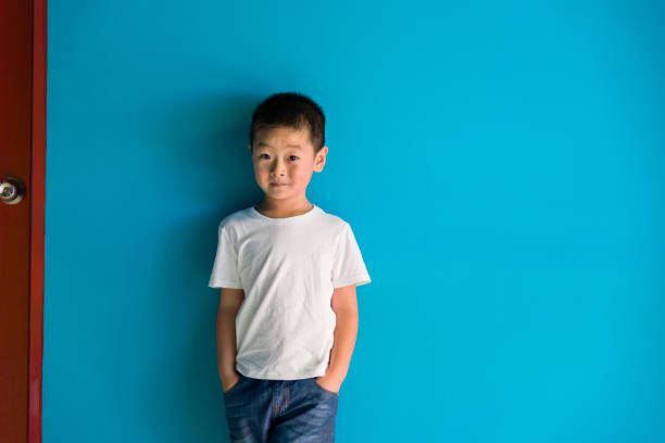 istock A cute boy standing in front of the blue wall 1464364219