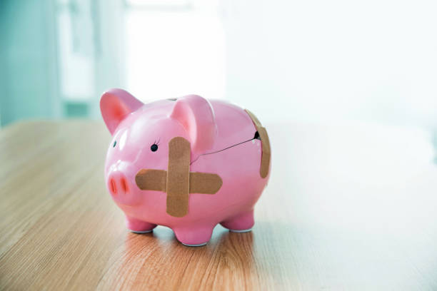 istock Broken piggy bank with adhesive bandage on the table 1464364502