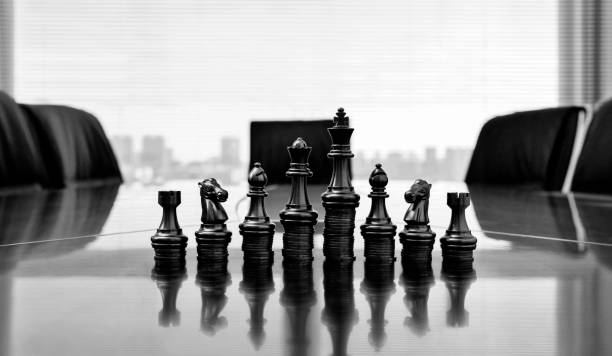 積み重ねられたコインの黒いチェスの駒 - chess board room business strategy ストックフォトと画像