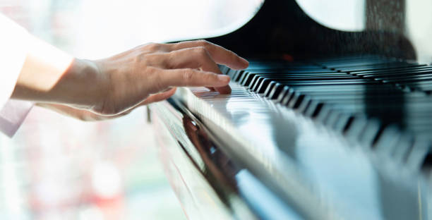 Close up of woman's hand playing the piano.