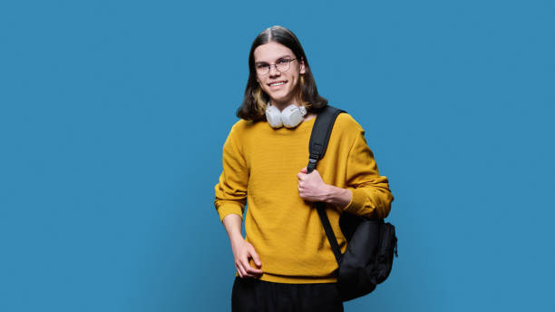 istock Portrait of university student guy on blue studio background 1464365341