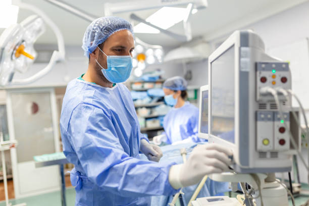 Medical ventilator being monitored by anaesthetist. surgeon using monitor in operating room. Medical ventilator being monitored by anaesthetist. surgeon using monitor in operating room. anaesthetist stock pictures, royalty-free photos & images