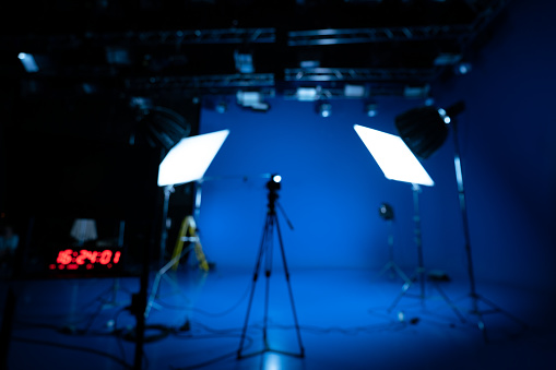 Professional video studio behind-the-scenes video footage behind-the-scenes silhouette production photography with a focus on camera and studio equipment.