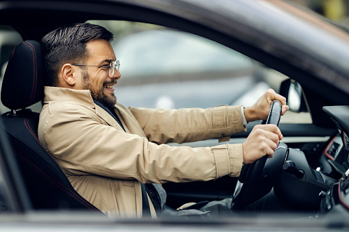 Portrait of a happy Brazilian man driving a car and smiling - lifestyle concepts