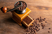 Vintage coffee grinder.Old retro hand-operated wooden and metal coffee grinder.Manual coffee grinder for grinding coffee beans on an old wooden background.selective focus, soft focus.