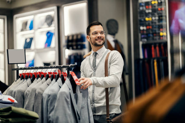 istock A happy man is choosing suit in a boutique. 1464366917