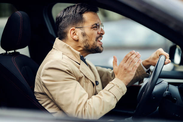 istock An angry man is cursing other drivers while sitting in a car and driving it. 1464368256