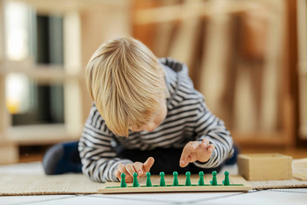 istock A boy is arranging figures on educational wooden toy and learning through the game at montessori kindergarten. 1464368600