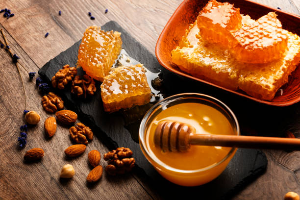 istock Honeycomb on slate tray with honey and nuts on kitchen table 1464370045