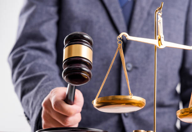 istock Man before the scales and judge hammer 1464371326
