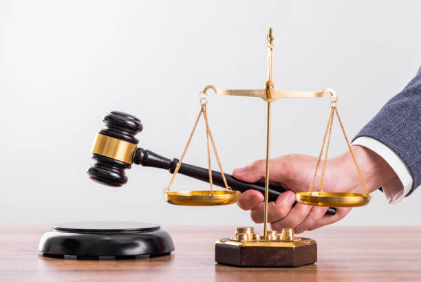 istock Man before the scales and judge hammer 1464371385