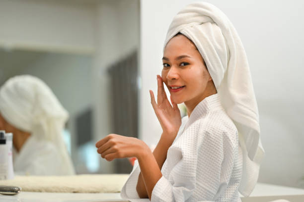 istock Cheerful millennial woman in bathrobe standing front of mirror and doing her everyday routine at home. 1464372499