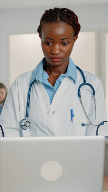 istock Woman doctor with stethoscope working with modern laptop 1464376992