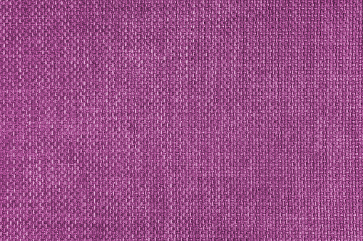 Jacquard woven upholstery, pink coarse fabric texture. Textile background, furniture textile material, wallpaper, backdrop. Cloth structure close up.