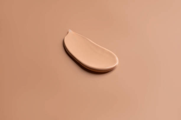 istock Make-up satin mousse foundation or bb-cream smudge. creamy beige stroke isolated on beige background 1464379551