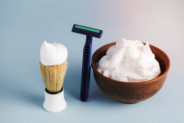 istock razor shaving brush bowl foam against blue backdrop 1464380634