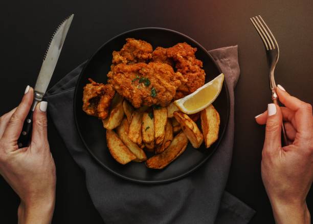 istock top view fish chips plate with woman holding cutlery 1464382208