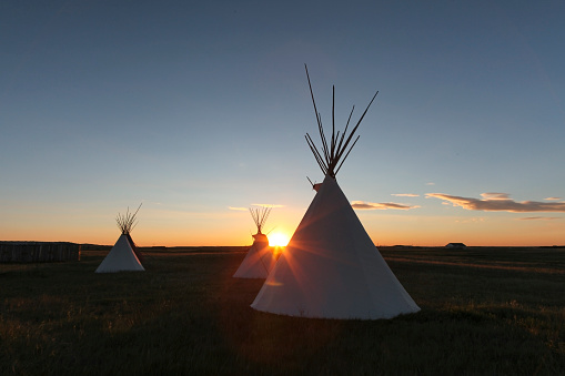 Silhouette of a Native American  teepee on landscape at sunrise, Browning, Montana, USA.
