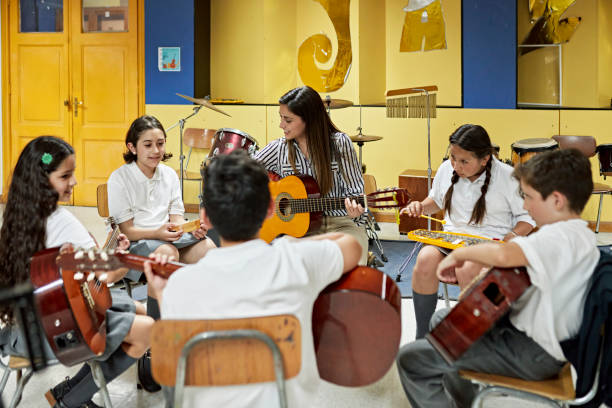 istock Female educator and school children playing instruments 1464387193