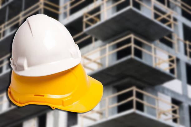 istock Yellow and white protection helmets isolated on white. Construction site. Head safety. Raw building concrete construction. 1464387858
