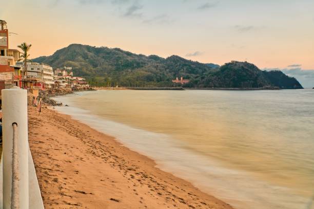 istock sunset on the beach and the sun is setting on the horizon 1464393507