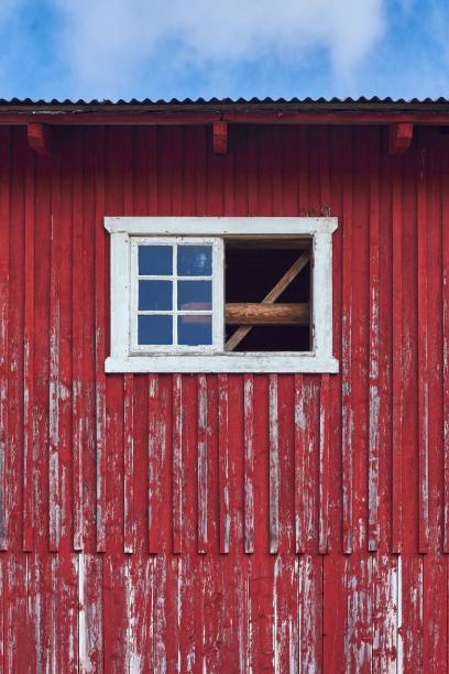 istock Vertical shot of the old red barn wall with white window 1464394946