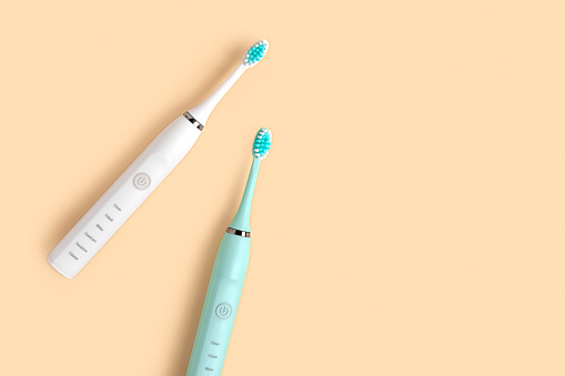 Electric Toothbrush. Top View, Flat Lay, Copy Space. Dental Care Supplies on Beige Pastel Studio Background. Oral Hygiene, Gum Health, Healthy Teeth. Modern Dental Ultrasonic Vibration Tooth Brush. sonic smart technology. bleaching