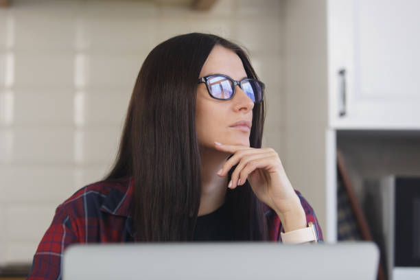 istock Portrait of pensive young woman in glasses thinking about problem solution. Freelancer female person looking away in thought 1464395111