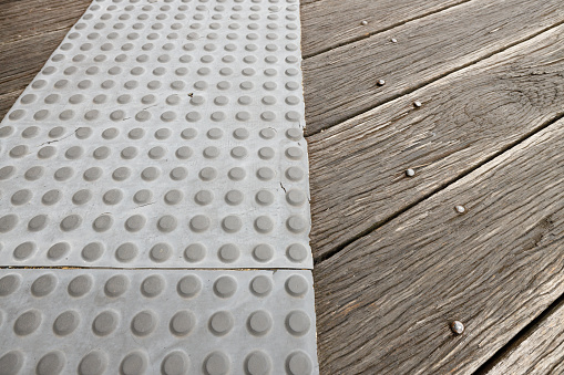 Pattern of studs on a rubber mat to prevent slipping on a wooden deck.