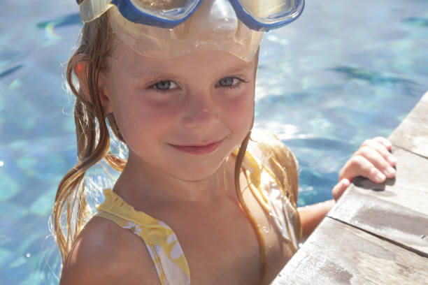 adorable niña alegre de 5 años con máscara de snorkel posando junto a la piscina - eyewear child glasses 6 7 years fotografías e imágenes de stock