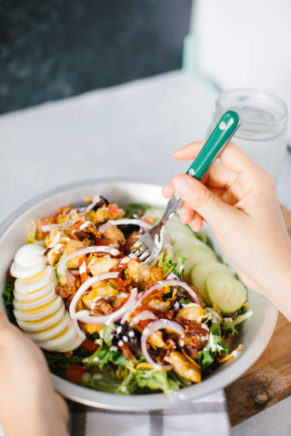 istock Holding a bowl of fresh salad with cucumbers 1464398221