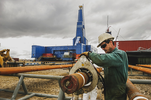 Sakhalin, Russia - July 30, 2013: A worker checks the fastening of a pipe at the construction site of an oil drilling rig in the Russian Far East. Sakhalin-1 project.
