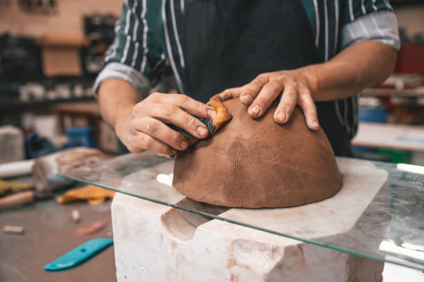 istock Closeup of a person making a clay pot on the table in a workshop 1464399531
