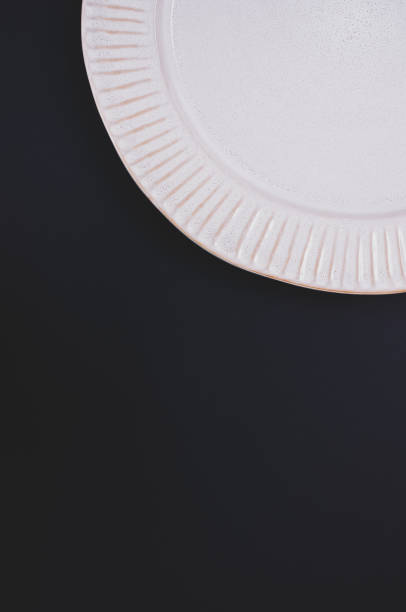 istock Vertical shot of a paper plate isolated on a black background with space for text 1464400952