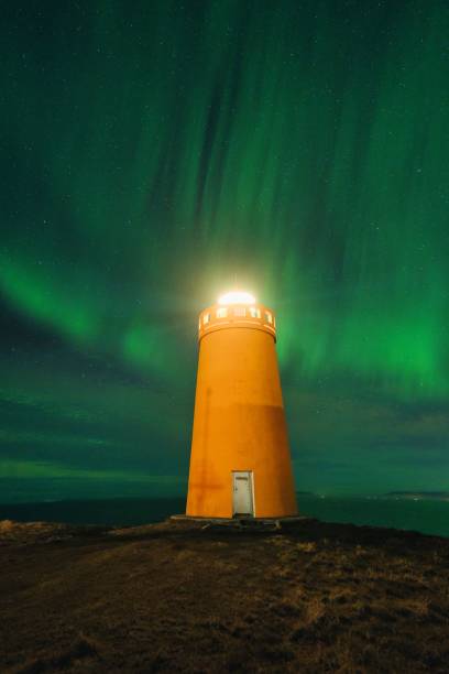 istock Northern lights aurora borealis over lighthouse in Iceland 1464401536