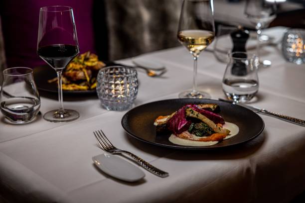 A dish with vegetables on a black plate at a restaurant