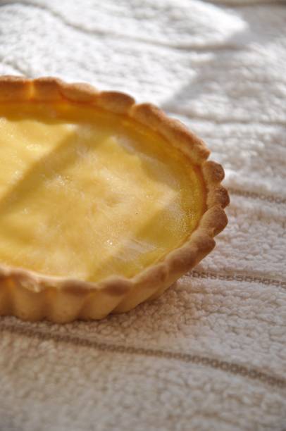 istock Vertical closeup of fresh egg tarts on a tablecloth in sunlight 1464402147