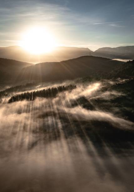 istock Vertical shot of a sunrise over mountains covered by clouds 1464402903
