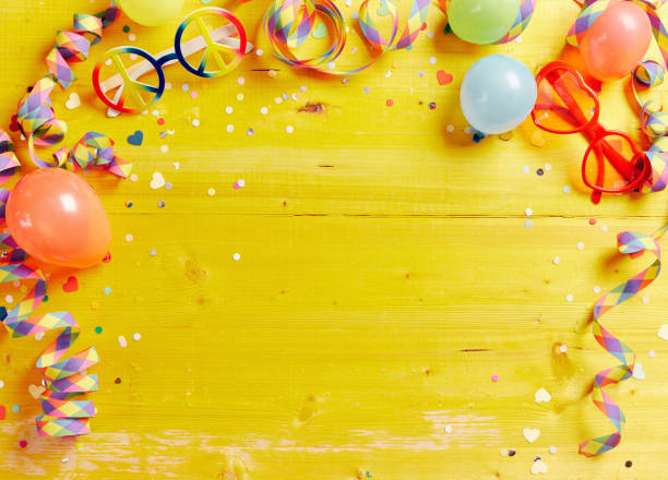 istock Various multicolored party supplies forming frame on bright yellow wooden surface 1464406481