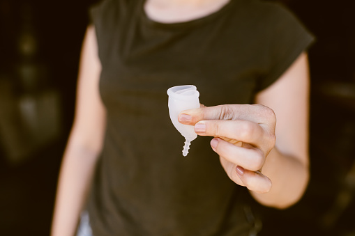 Mujer sosteniendo una copa menstrual doblada photo