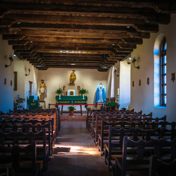 Mission Espada inside the chapel of Missions National Historical Park in San Antonio, Texas, USA, Catholic church interior architecture with tranquil sunrays over the benches