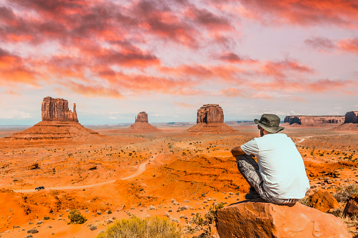 A young boy sitting on a stone in the Monument Valley National Park Utah