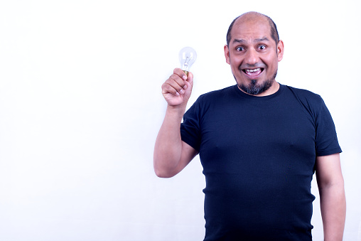 Man on a white background with a light bulb in his hand, expresses a gesture of having found a great idea.