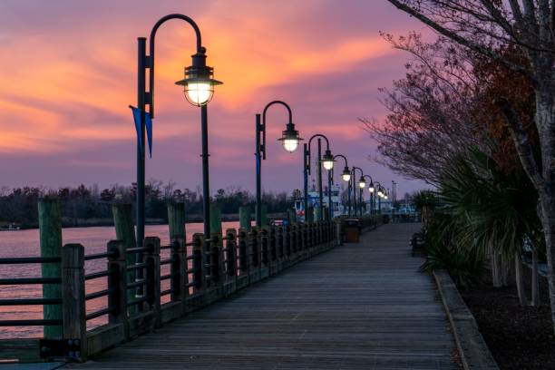 istock Empty boardwalk illuminated by lanterns during beautiful sunset in Wilmington, North Carolina 1464414317