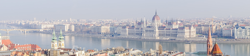 A panoramic shot of a river along the cityscape in Budapest, Hungary