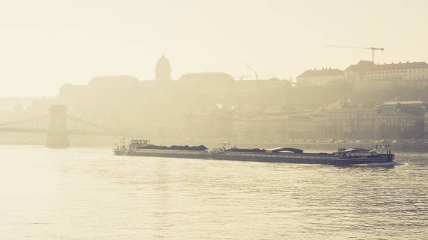 istock Longboat passing on a river passing through a bridge in Budapest, Hungary during a foggy morning 1464414905