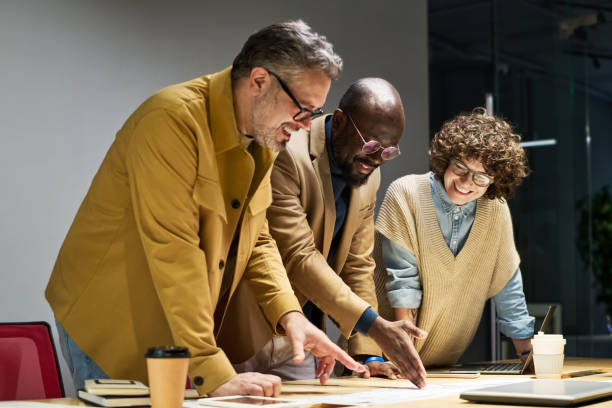 istock Group of three intercultural brokers discussing financial document 1464415037
