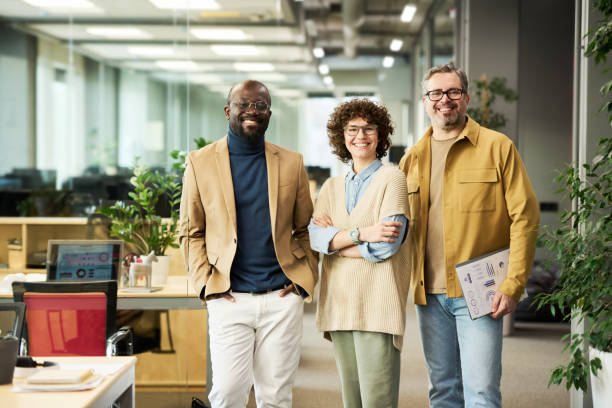 istock Three successful managers or brokers in smart casualwear looking at camera 1464417987