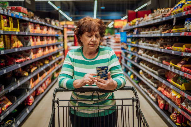 Senior woman checking shopping list on smartphone stock photo